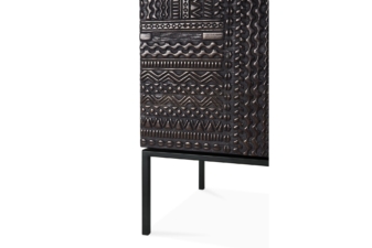 Close-up detail of the carved dark wood front panel and black metal leg of a sideboard.