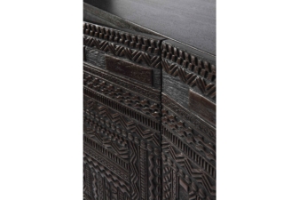 Close-up detail of the Ethnicraft Tabwa carved wood sideboard showing intricate geometric patterns and textured dark timber finish.