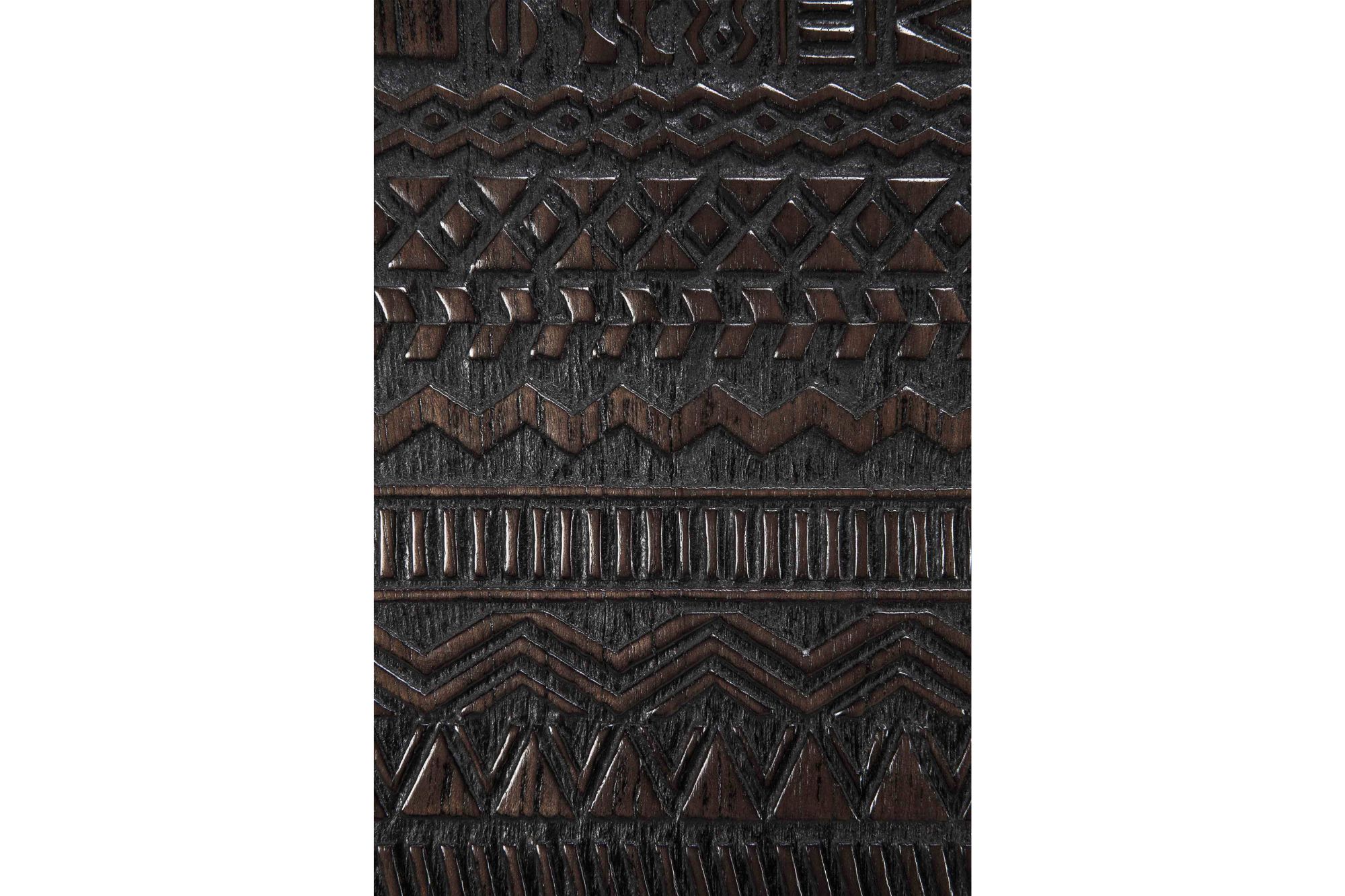 Close-up detail of the Ethnicraft Tabwa sideboard showing intricate hand-carved geometric wood patterns and textured dark timber finish.