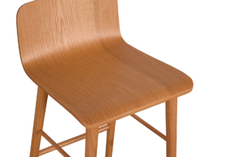 Close-up view of a wooden bar stool with a smooth, curved oak seat and natural finish.