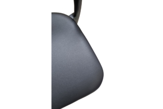 Close-up of a black textured chair seat with smooth curved edges and a modern matte finish.