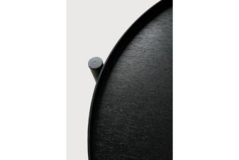 Close-up view of a modern black round side table, showcasing its smooth wood grain texture and minimalist cylindrical leg attachment.