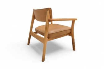 Side view of a modern armchair with natural oak frame and tan leather seat and backrest.