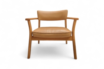 Front view of a modern armchair with natural oak frame and soft tan leather seat and backrest.