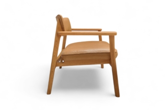 Side view of a wooden armchair with natural oak finish and soft tan leather seat and backrest.